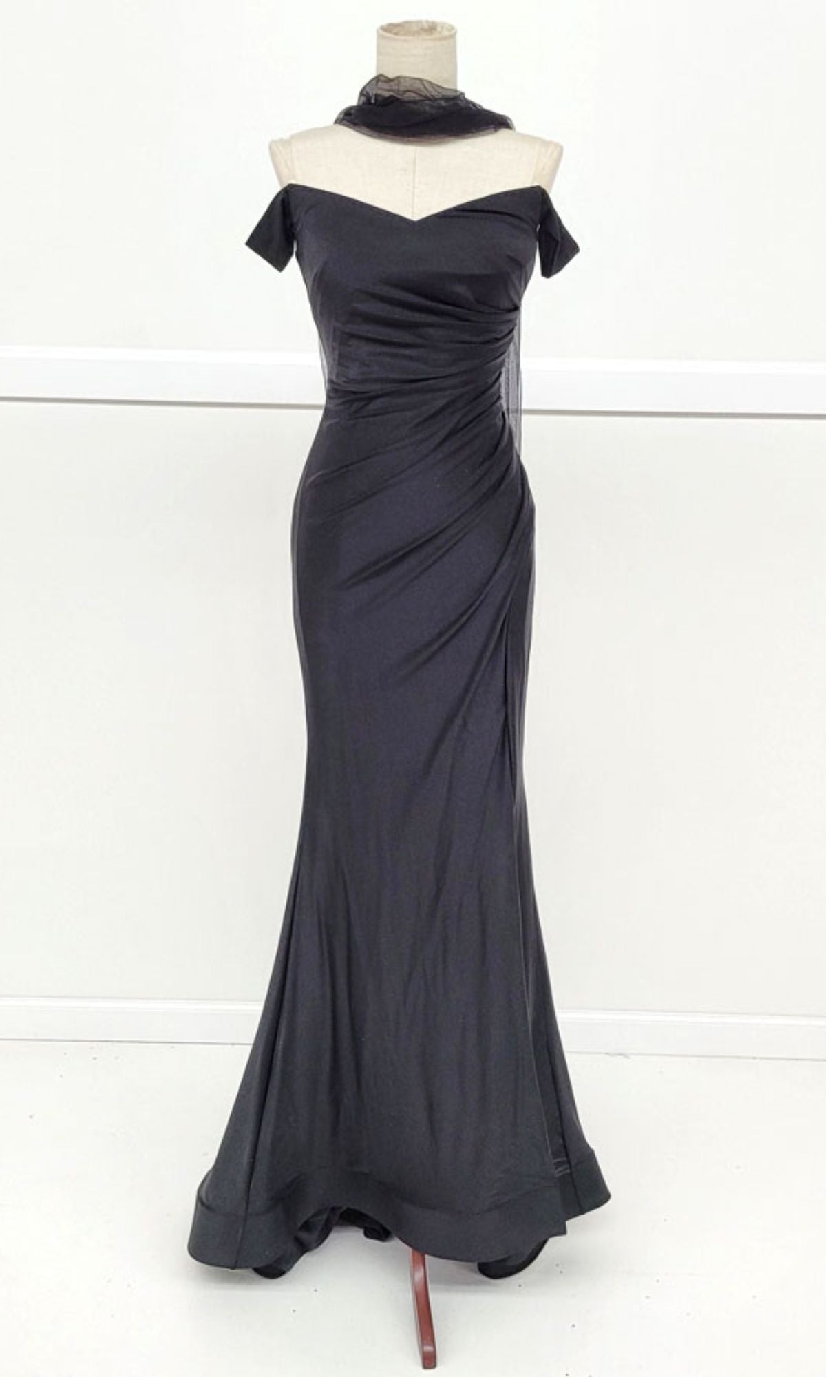 The Off-the-Shoulder Long Prom Dress: Chicas YG5025, shown in black and floor-length, is displayed on a dress form against a plain white background.